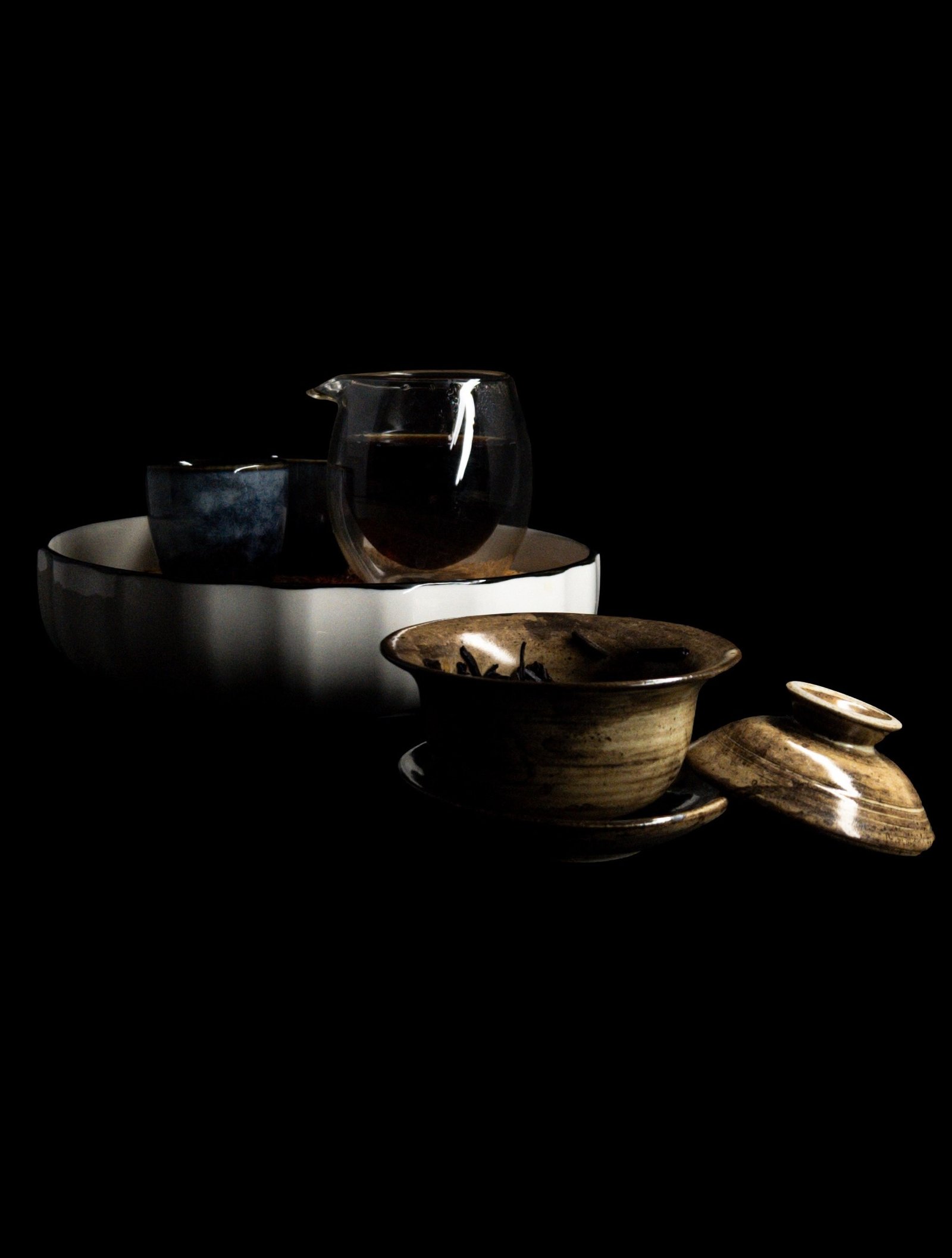 A small collection of contemporary teaware arranged against a black background