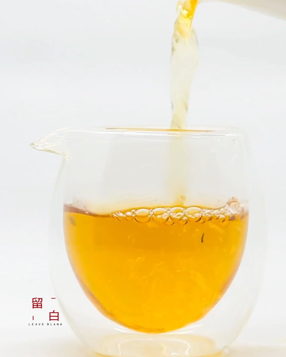 Amber tea being poured into a clear fairness pitcher